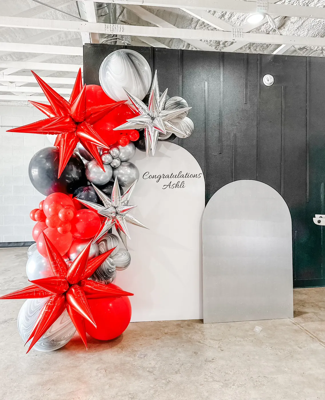Red and silver balloons around the wooden backdrop