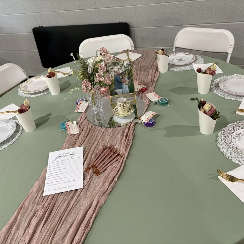 A sage tablecloth and pink runner set for a bridal shower