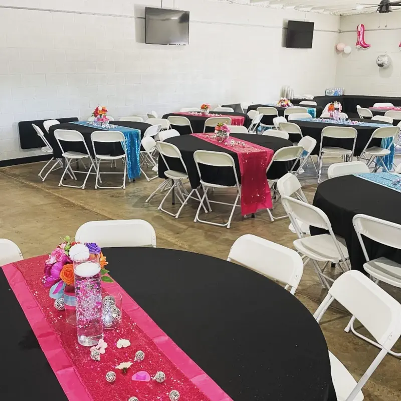 Black tables with hot pink runners and floral centerpieces