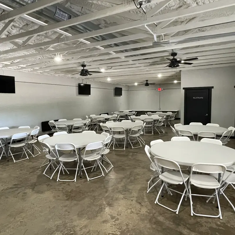 The hall with white tables and chairs, ready to decorate