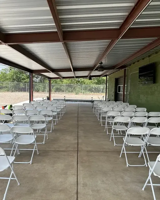 Rows of white chairs on the patio for a ceremony
